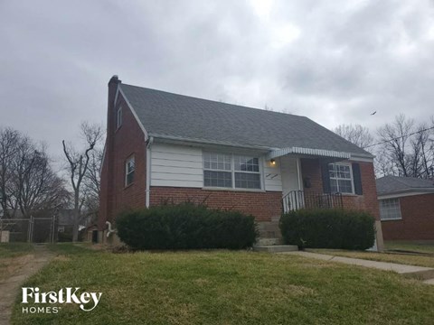 A brick house with a white door and windows.