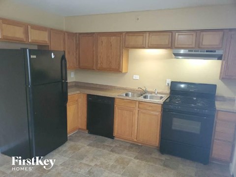 A kitchen with wooden cabinets and black appliances.