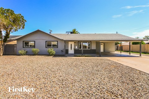 a small house with a gravel driveway and a roof