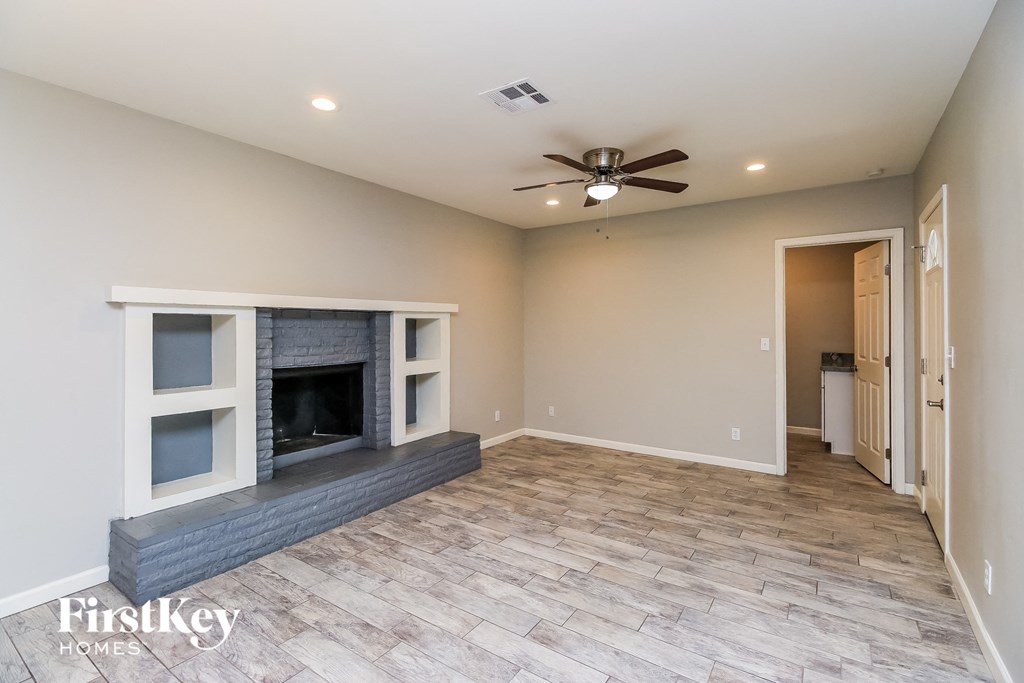 a living room with a fireplace and a ceiling fan