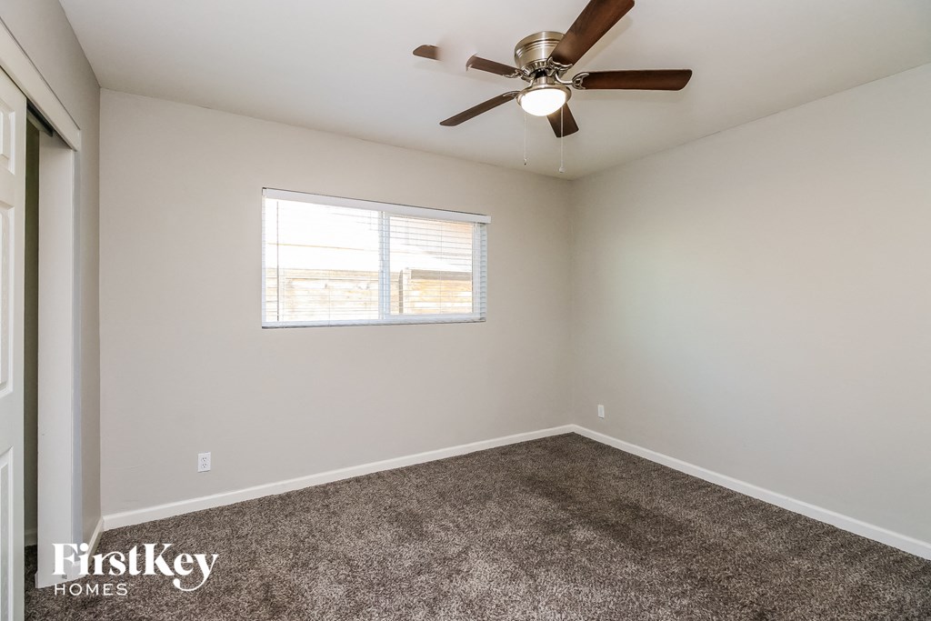 a bedroom with a ceiling fan and a window