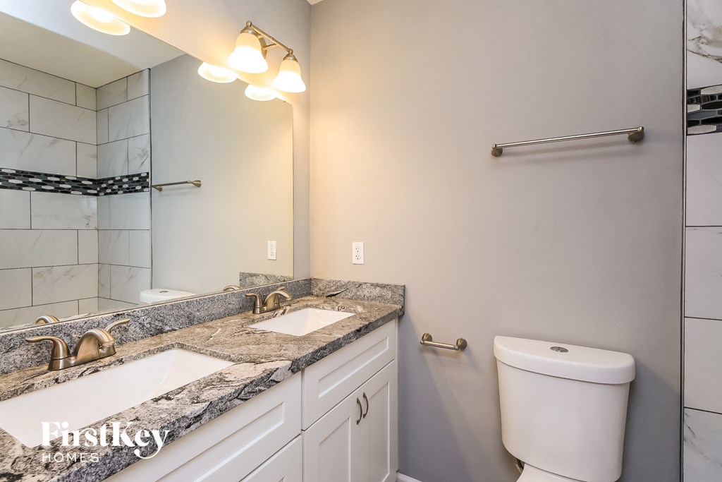 a bathroom with a toilet and a sink and a mirror