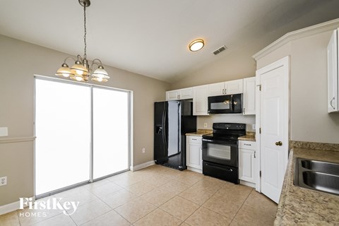 a kitchen with black appliances and white cabinets