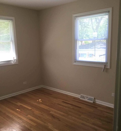A room with a window and wooden flooring.