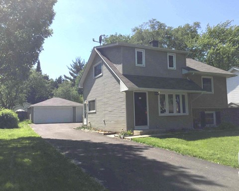 A house with a garage and a driveway in front.