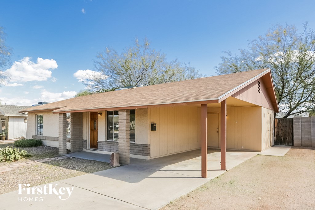 a small yellow house with a porch and a driveway