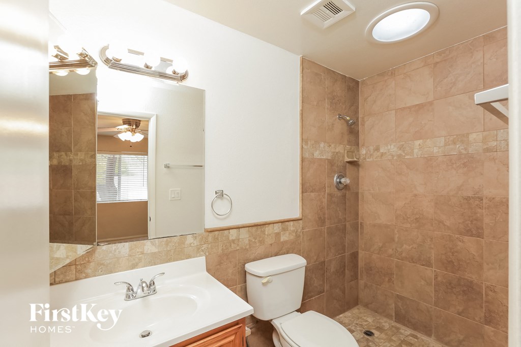 a bathroom with a sink toilet and a mirror