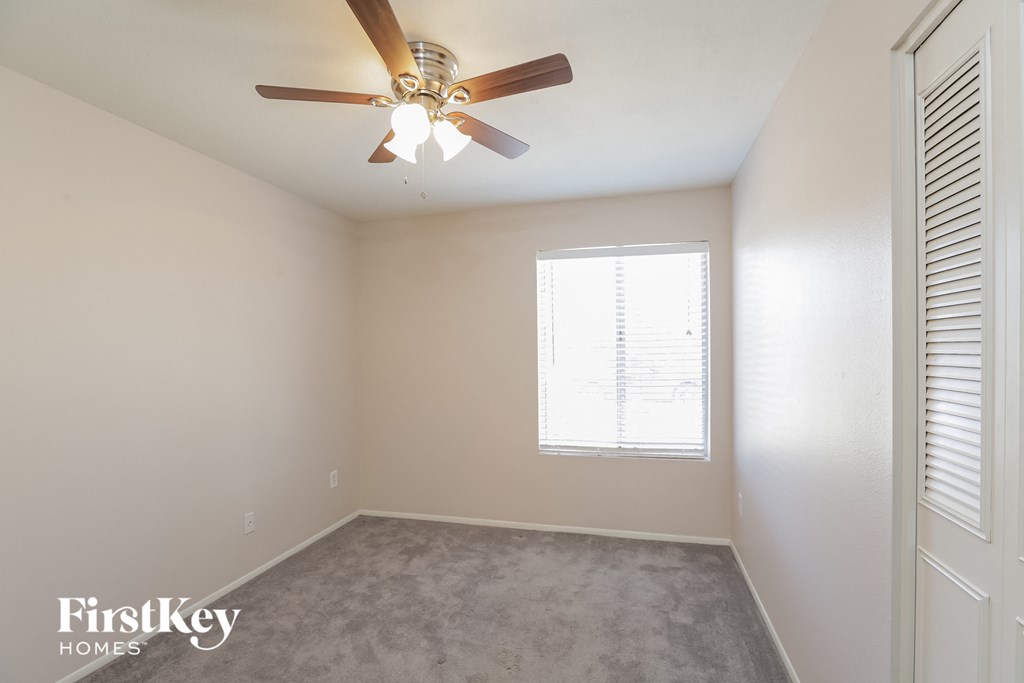 a bedroom with a ceiling fan and a window