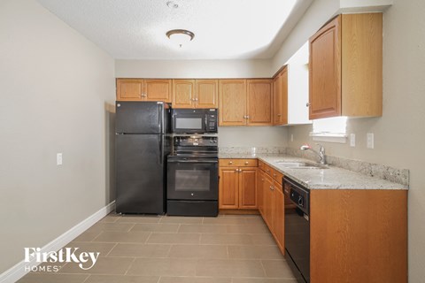 A kitchen with wooden cabinets and black appliances.