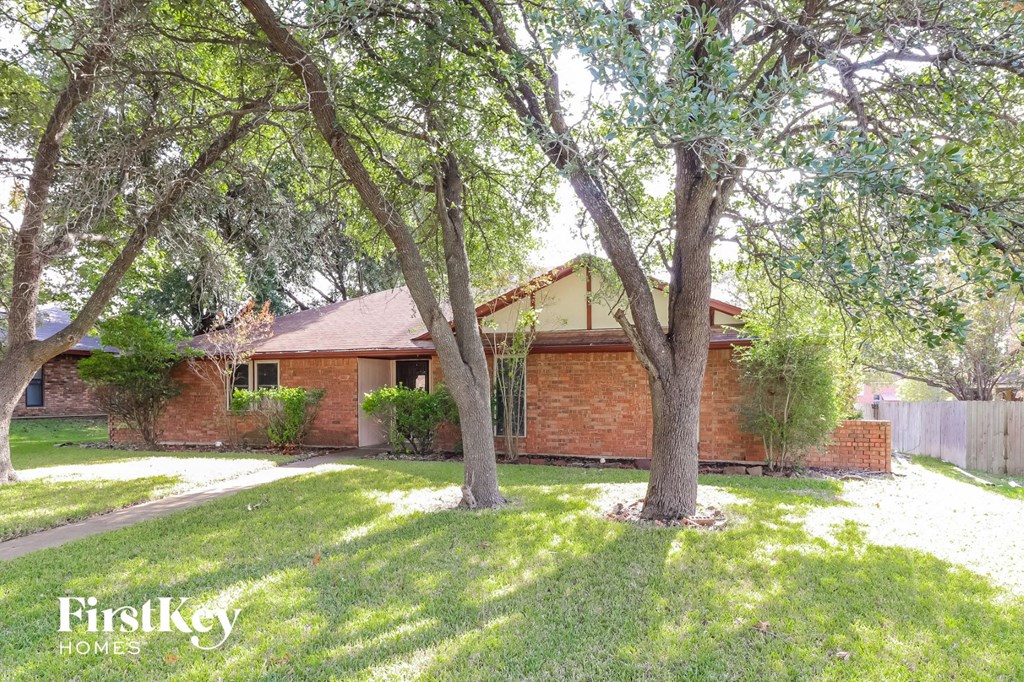 a brick house with trees in the yard