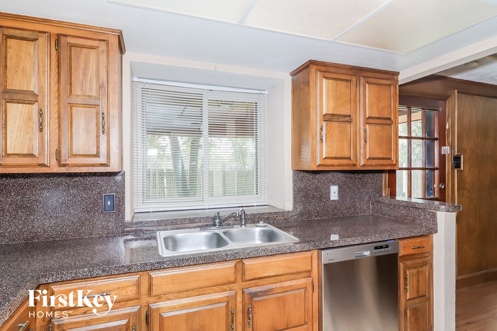 a kitchen with wooden cabinets and a sink and a window