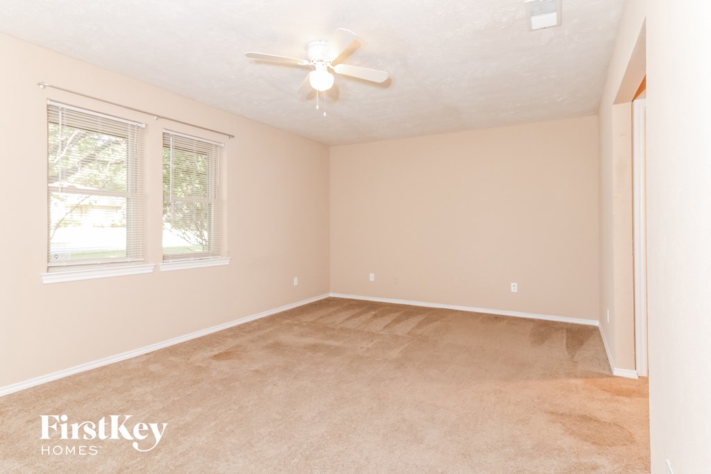 a bedroom with a carpeted floor and a ceiling fan