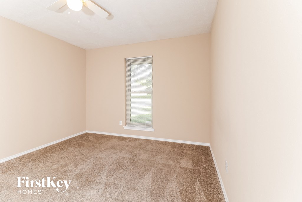 a bedroom with a carpeted floor and a window