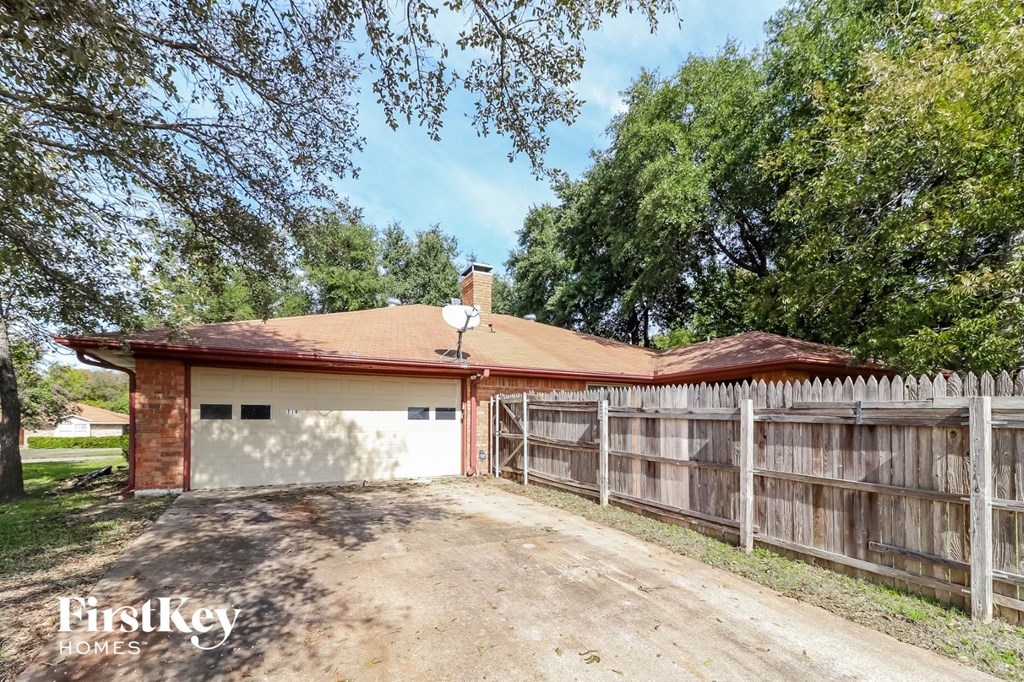 a garage with a red roof and a wooden fence