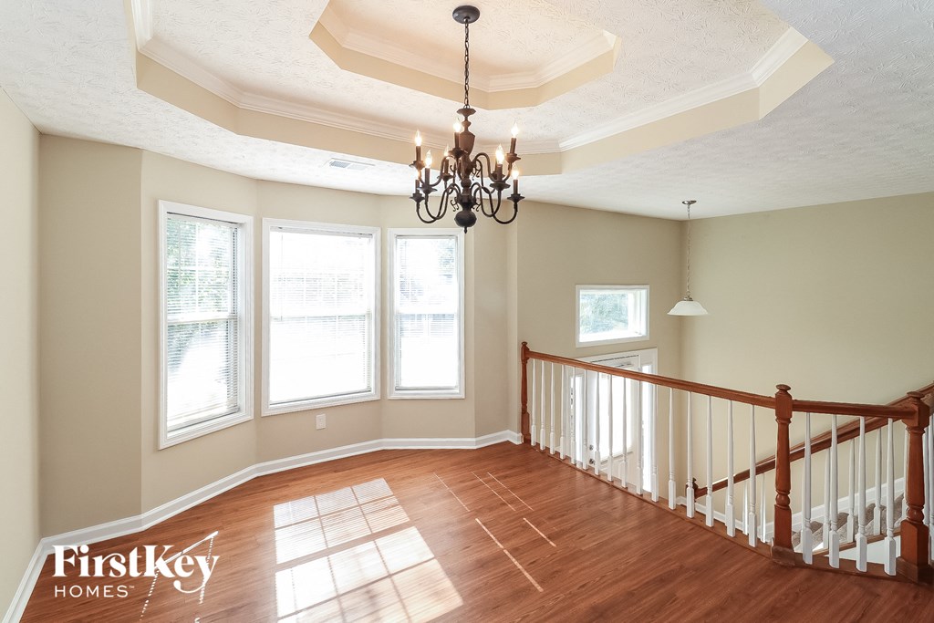 a living room with a staircase and a chandelier