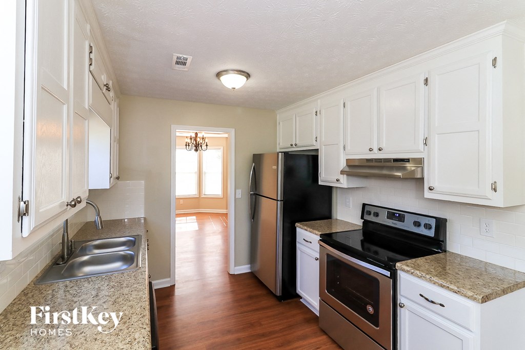 a kitchen with white cabinets and stainless steel appliances