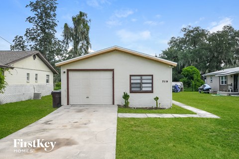 a small white house with a garage and a driveway