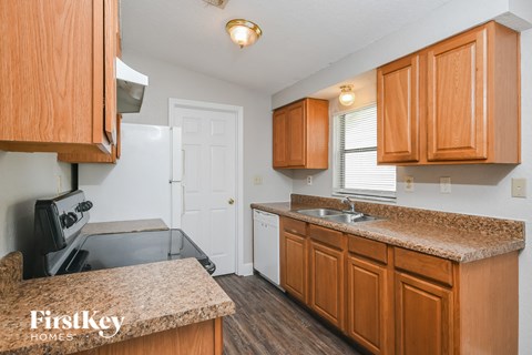 a kitchen with wood cabinets and granite counter tops and a sink