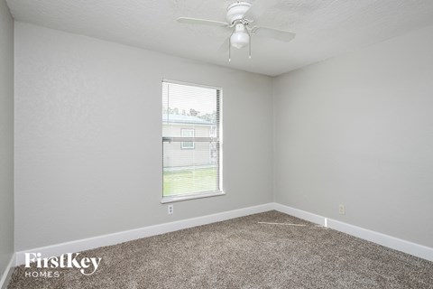 a bedroom with carpet and a ceiling fan