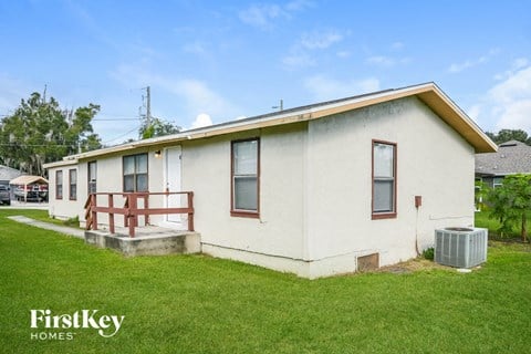 an old with a porch and a grass yard