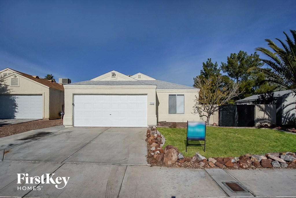 a home with a white garage door and a chair on the driveway