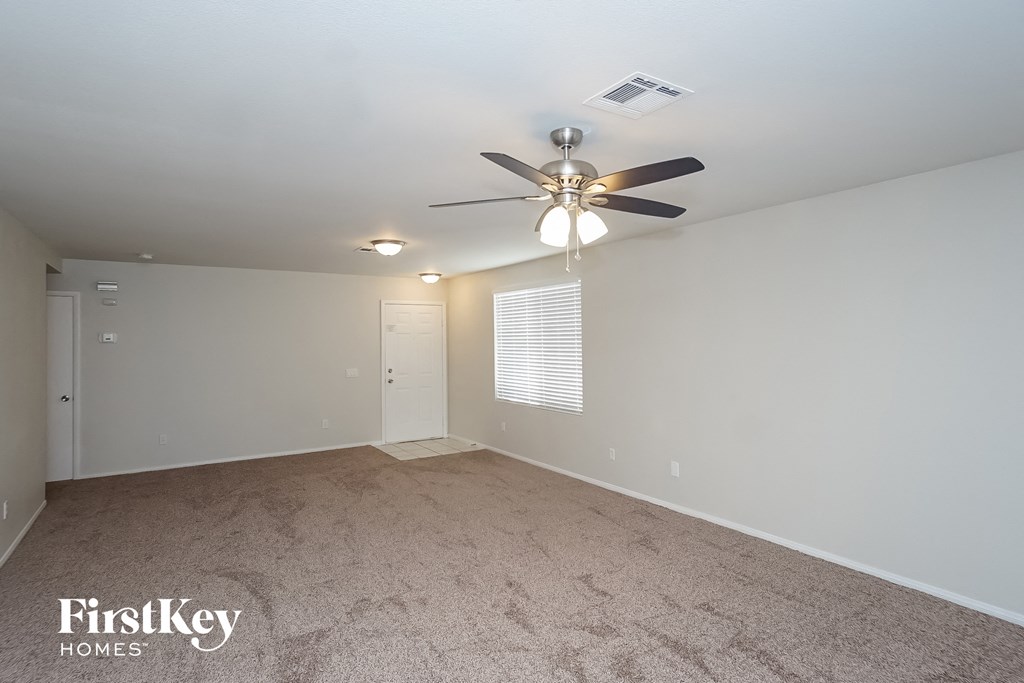 the living room has a ceiling fan and a carpeted floor
