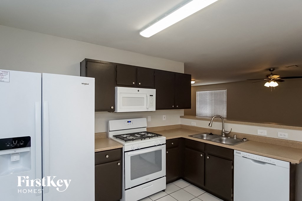 a kitchen with white appliances and black and white cabinets