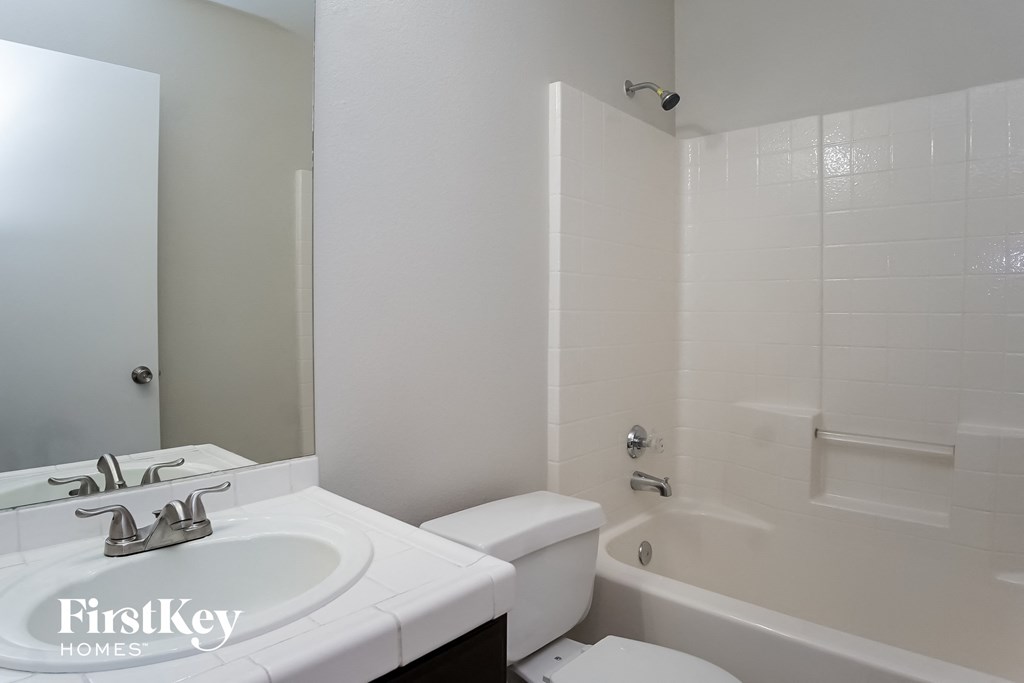 a bathroom with a sink toilet and tub and a mirror