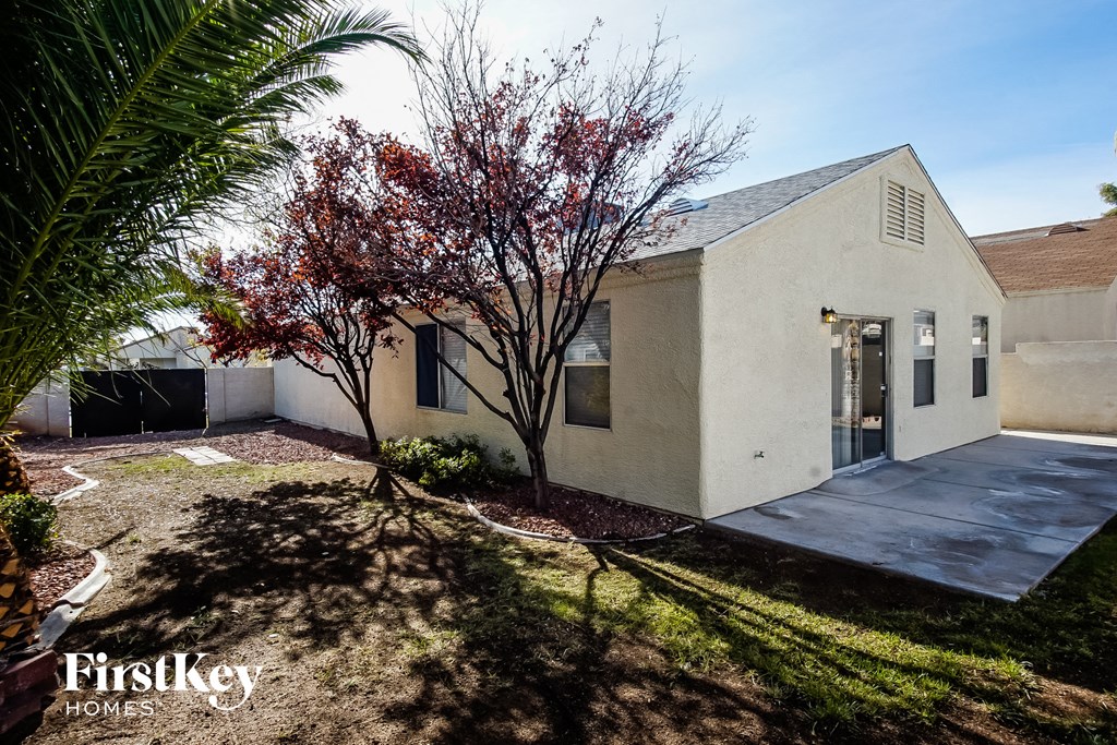 a white house with a yard and a tree