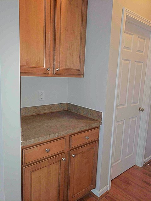 A kitchen with wooden cabinets and a white door.