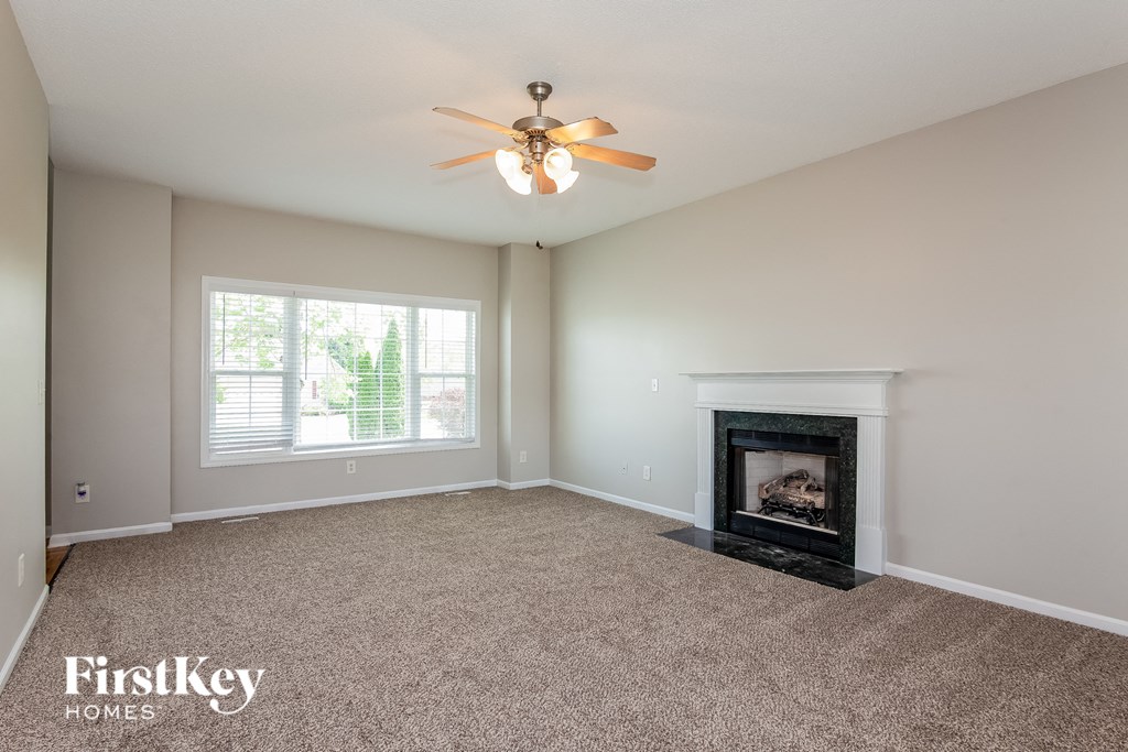 a living room with a fireplace and a ceiling fan