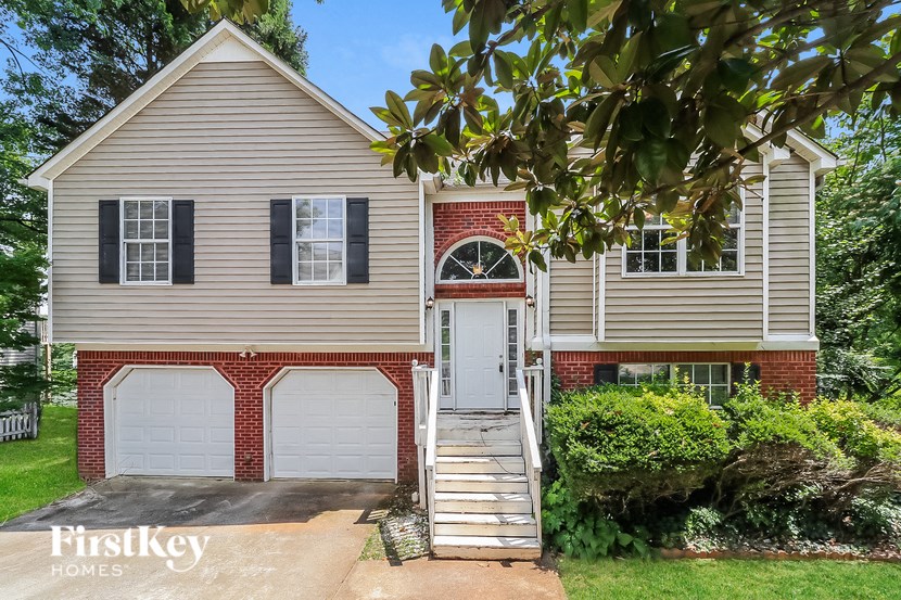 a renovated house with two garage doors and a staircase
