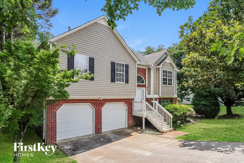 the front of a house with two garage doors and a driveway