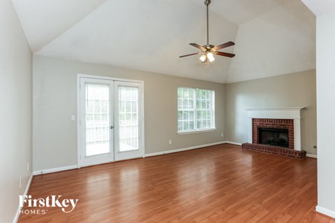 A room with a fireplace and a ceiling fan.