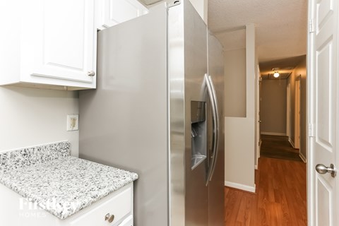 A stainless steel refrigerator with a water and ice dispenser in a kitchen.