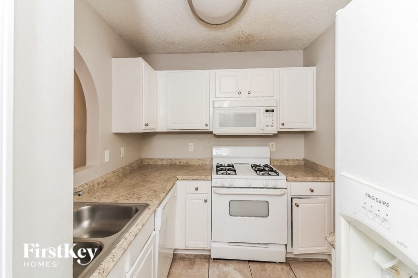a kitchen with white appliances and white cabinets