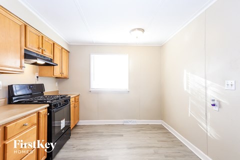 a kitchen with wood cabinets and a stove and a window