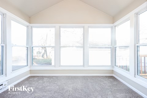 a living room with five windows and a carpeted floor