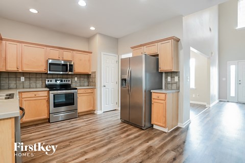 A kitchen with wooden cabinets and a stainless steel refrigerator.