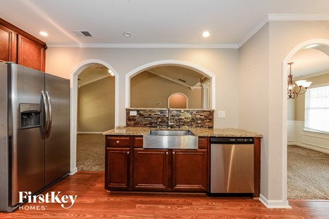A kitchen with a stainless steel refrigerator and a granite countertop.