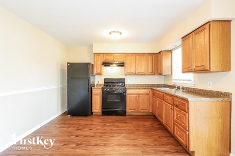 a kitchen with wooden cabinets and a black stove and refrigerator
