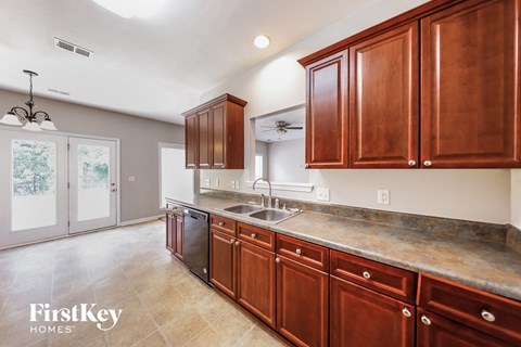 A kitchen with wooden cabinets and a marble countertop.