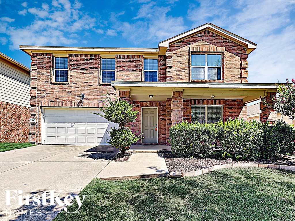 the front of a brick house with a white garage door