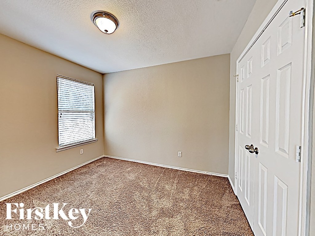 an empty bedroom with a white door and a window