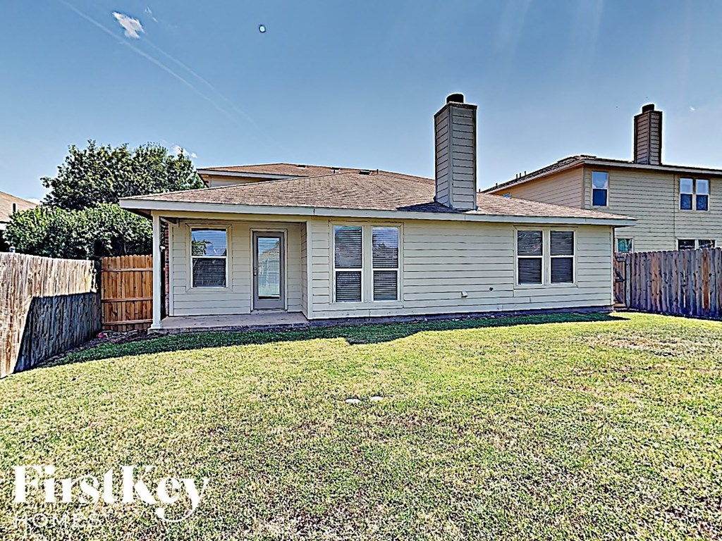 a small white house with a yard and a fence