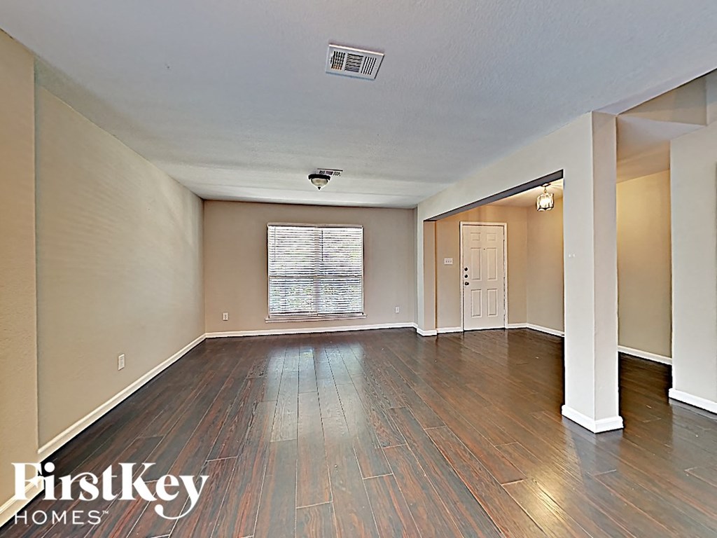 an empty living room with hardwood floors and a window