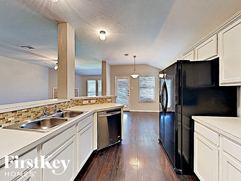 a large kitchen with stainless steel appliances and white cabinets