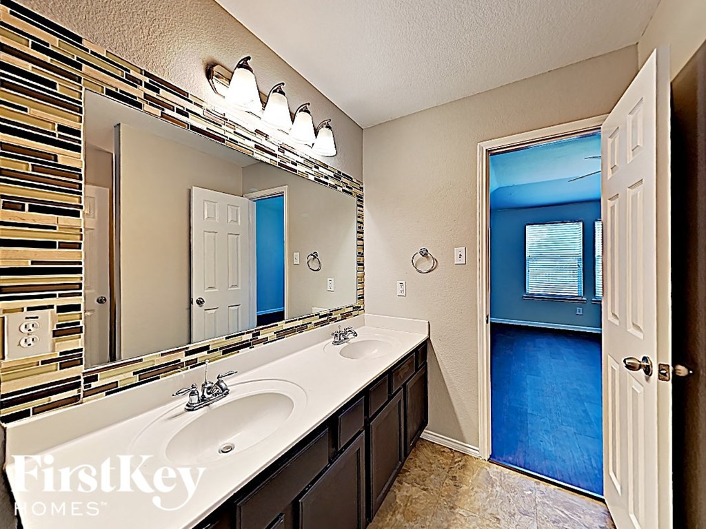 a bathroom with two sinks and a large mirror
