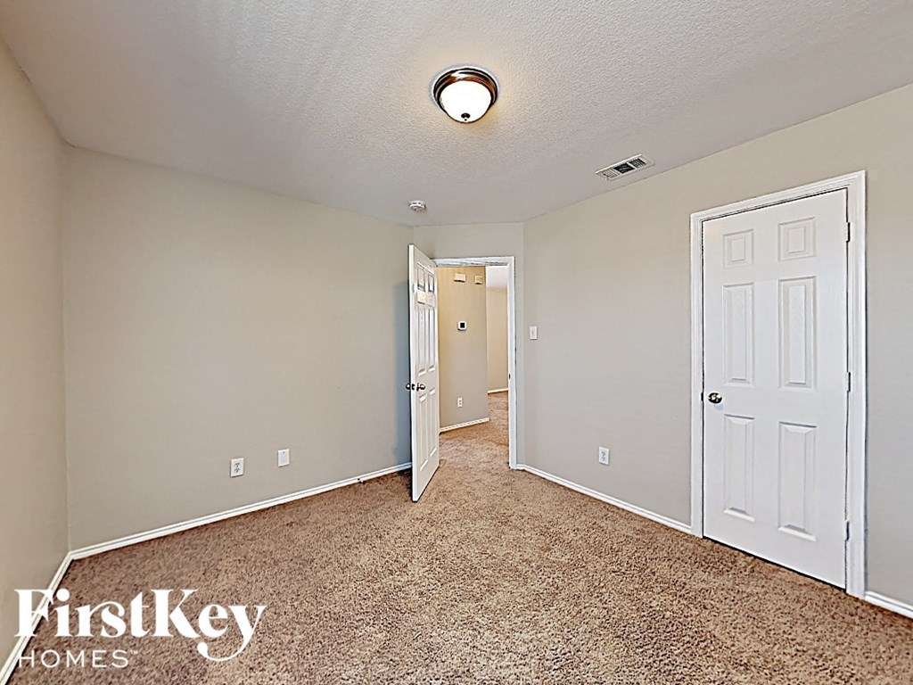 a bedroom with a closet and a door to a hallway