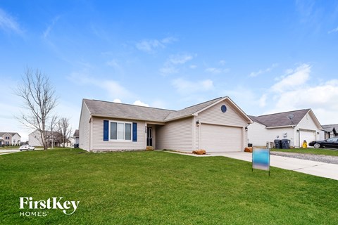 a house with a lawn and a blue sign in front of it